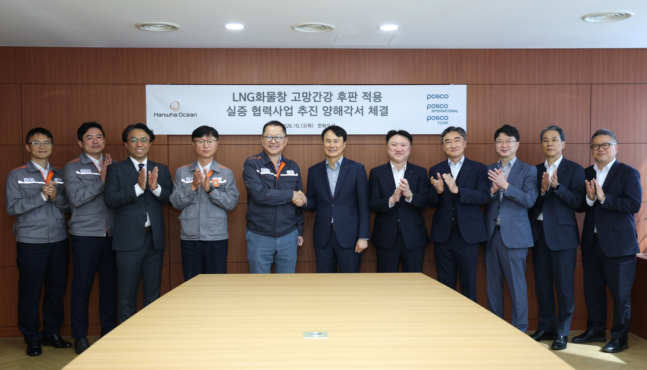 Posco CEO Lee Hee-geun (sixth from left), Hanwha Ocean CEO Kim Hee-cheul (fifth from left) and other company officials pose for a photo at a memorandum of understanding signing ceremony in Geoje, South Gyeongsang Province, Thursday. (Posco)