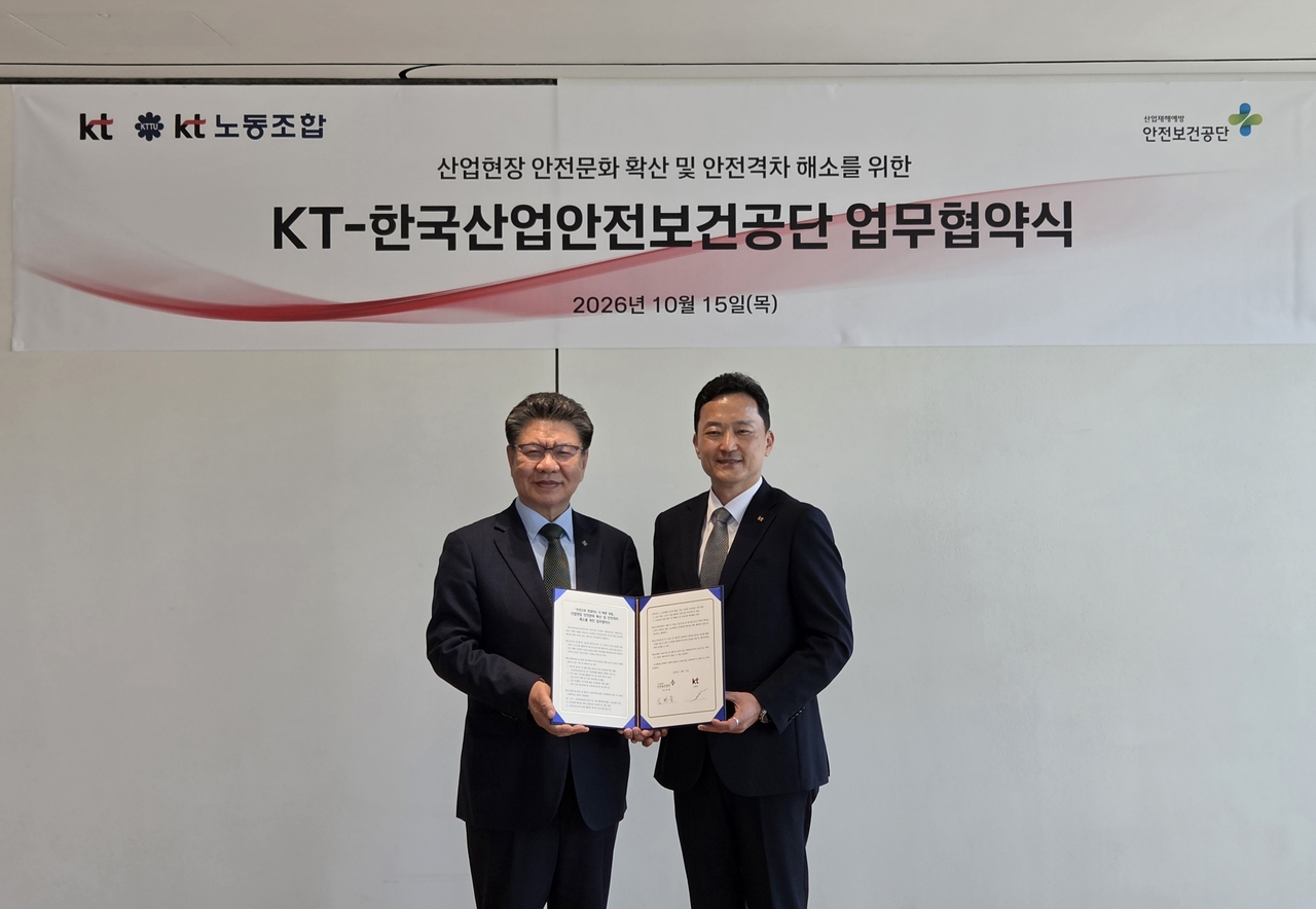 Korea Occupational Safety and Health Agency President Kim Hyun-joong (left) and KT Corp Executive Vice President Kim Young-in (right) sign an MOU to promote a safety culture and close the safety gap. [Korea Occupational Safety and Health Agency]