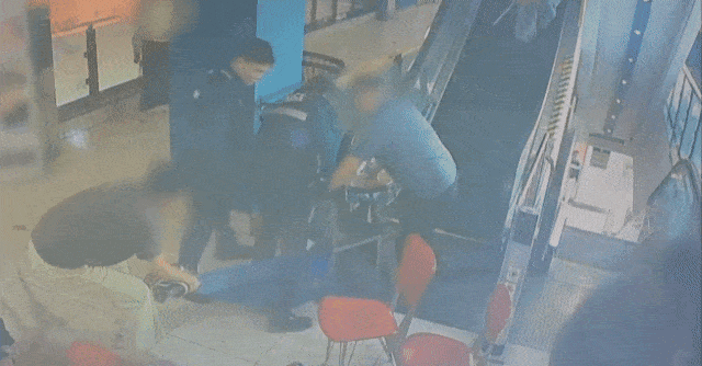 People subdue suspect as he rides an escalator at an Incheon shopping complex on Tuesday. (Incheon Metropolitan Police Agency)