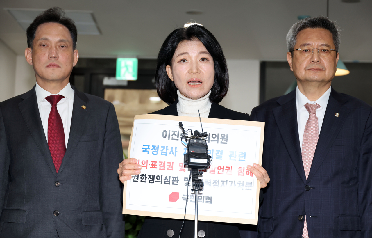 People Power Party lawmaker Lee Jin-suk speaks to reporters as she heads to the petition office of the Constitutional Court in Jongno-gu, Seoul, on Thursday. Lee submitted an injunction application and a competence dispute petition to the court related to her exclusion vote. From left: lawmakers Kim Tae-gyu, Lee and Kim Jang-gyeom. [Yonhap]