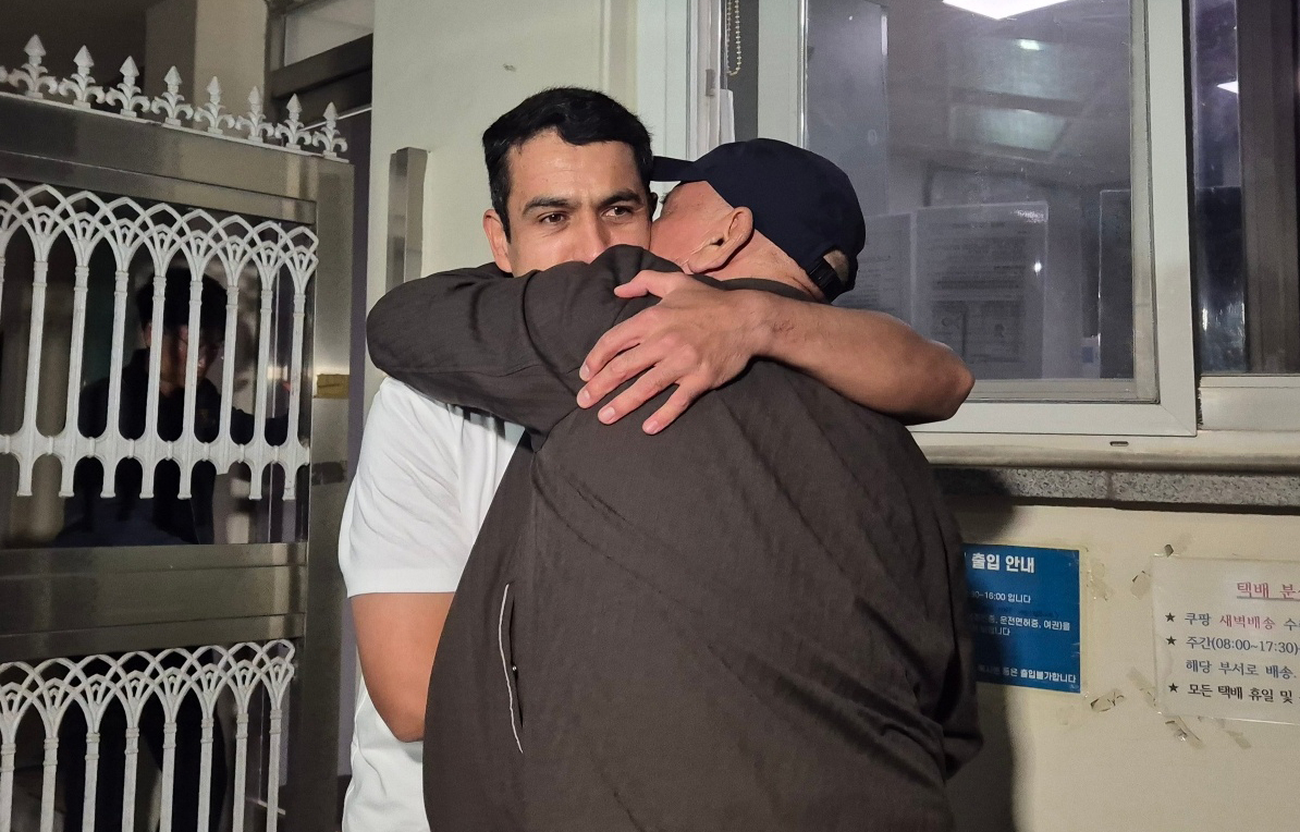 법원의 재심 개시와 형집행정지 결정으로 약 17년 만에 풀려난 우즈베키스탄 국적의 보조로브 아크말(37)씨가 15일 오후 경남 창원시 마산회원구 창원교도소 정문에서 마중 나온 부친과 포옹하고 있다. 아크말씨는 2009년 창원에서 택시 기사를 살해한 혐의로 무기징역을 선고받았다. [연합]