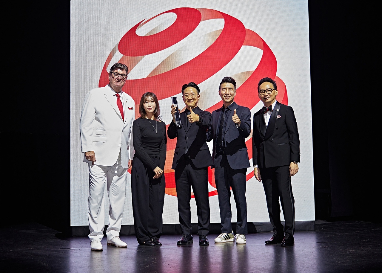 Red Dot CEO Peter Zec (left), three Hankook Tire project members behind the iFlex Gen2, and Red Dot Asia-Pacific President Ken Koo pose for a photo. [Hankook Tire & Technology]