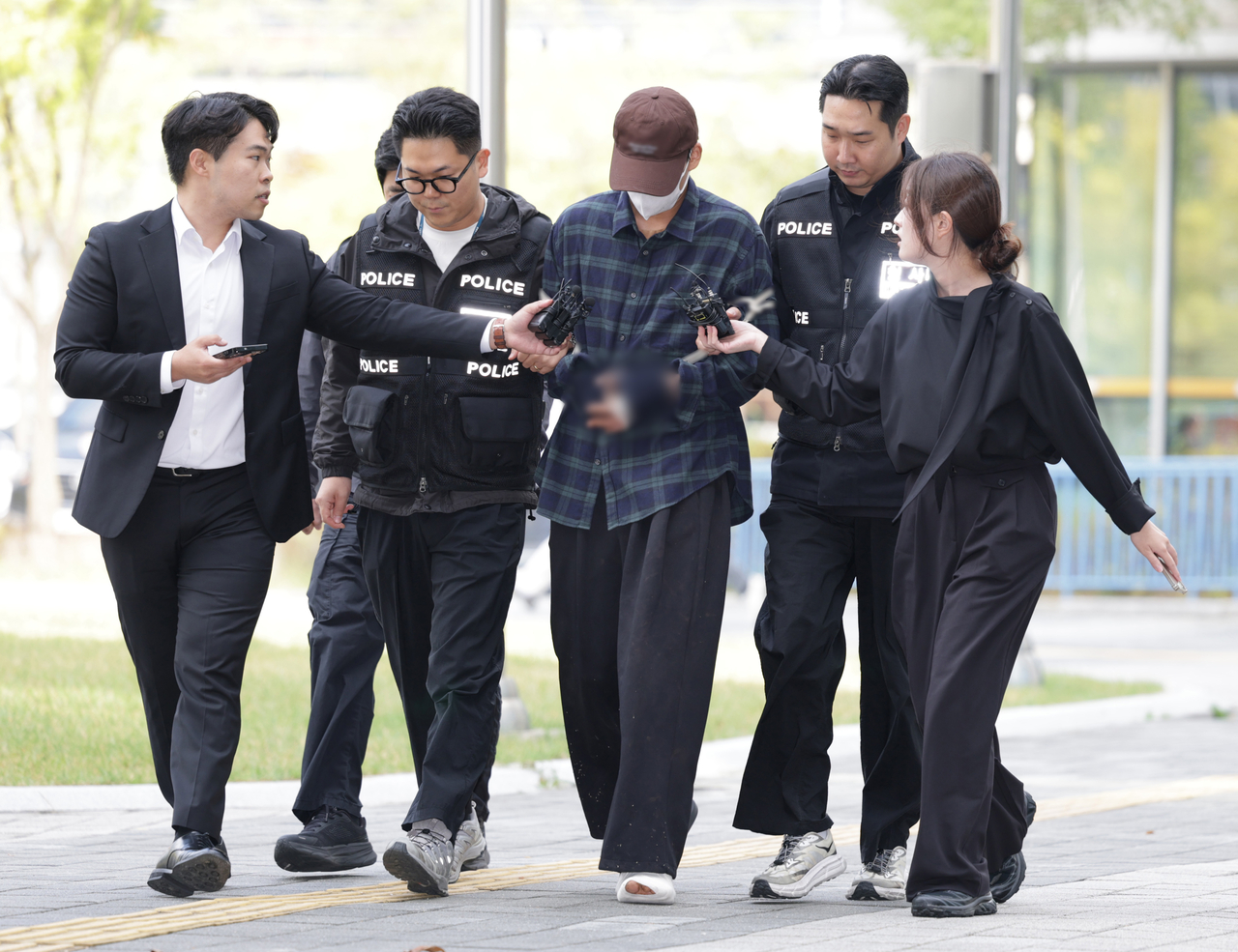 A man in his mid-20s suspected of killing his mother-in-law and abducting his wife amid divorce proceedings arrives at the Seoul Eastern District Court in Songpa-gu, Seoul, Tuesday, for a hearing on a warrant for his detention. (Yonhap)