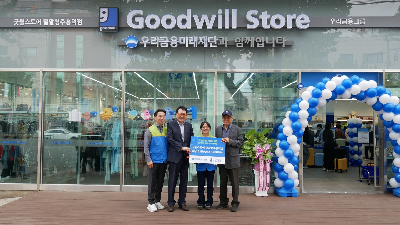Jang Gwang-ik, secretary general of the Woori Financial Future Foundation, Kim Ji-woo, a staff member at Goodwill Store Milal Cheongju Heungdeok, and Hong Jeong-gil, chairman of the Milal Welfare Foundation, pose for a photo at the opening ceremony of the Goodwill Store Milal Cheongju Heungdeok branch in Heungdeok-gu, Cheongju, North Chungcheong Province, on Thursday.
