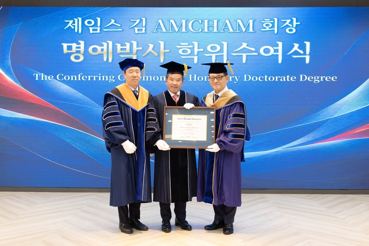 James Kim (center), chair and CEO of AmCham Korea, receives his honorary doctorate certificate from Korea Aerospace University Graduate School Dean Ahn Jun-sun (left) and President Heo Hee-young (right), at the university’s Vision Hall, in Goyang, Gyeonggi Province, Thursday. (AmCham Korea)