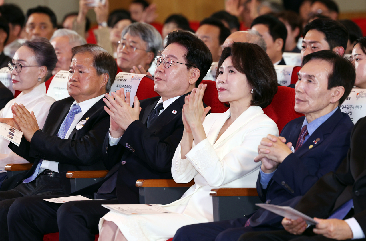 이재명 대통령과 김혜경 여사가 16일 부산시청에서 열린 부마민주항쟁 47주년 기념식에서 주제 공연을 본 후 박수 치고 있다. [연합]