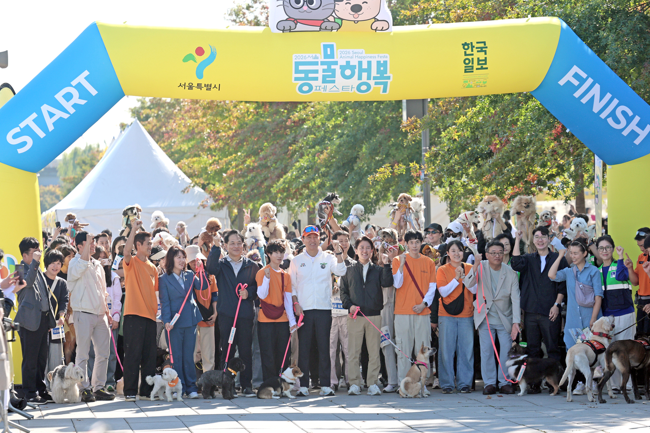 Seoul Mayor Oh Se-hoon (center) poses for a photo with other participants before the start of a run with dogs during the third Seoul Animal Protection Day event at Yeouido Hangang Park in Seoul on Saturday. (Newsis)