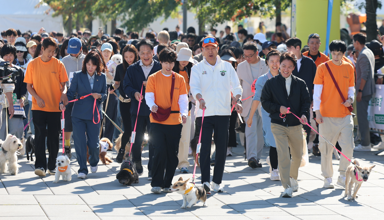 Seoul Mayor Oh Se-hoon (center) runs with a leashed dog alongside participants during the third Seoul Animal Protection Day event at Yeouido Hangang Park in Seoul on Saturday. (Newsis)