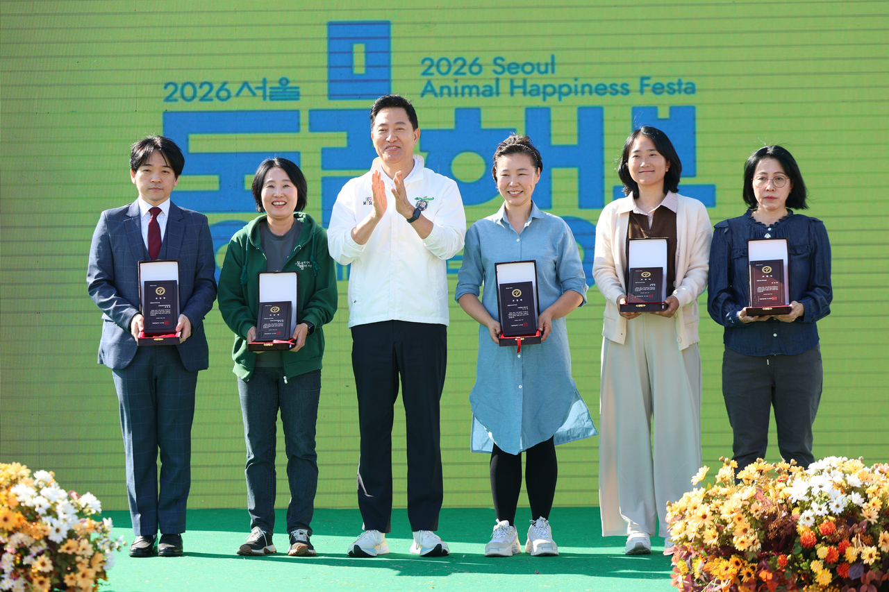 Seoul Mayor Oh Se-hoon (third from left) poses for a photo on stage with recipients of mayoral commendations during the third Seoul Animal Protection Day event at Yeouido Hangang Park in Seoul on Saturday. (Newsis)