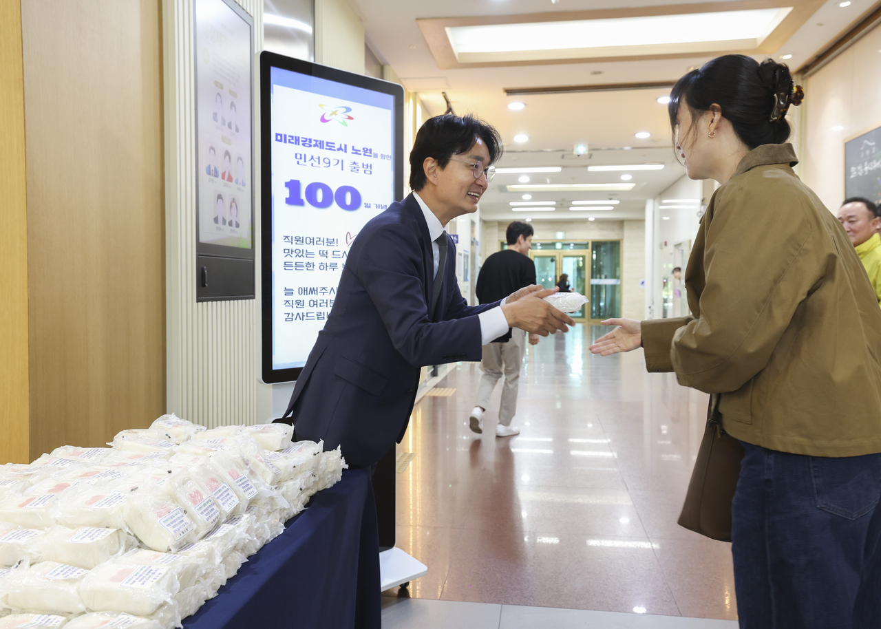Nowon District Mayor Seo Jun-o (left) greets employees and shares rice cakes with them on the morning of Wednesday, the 100th day of his tenure.