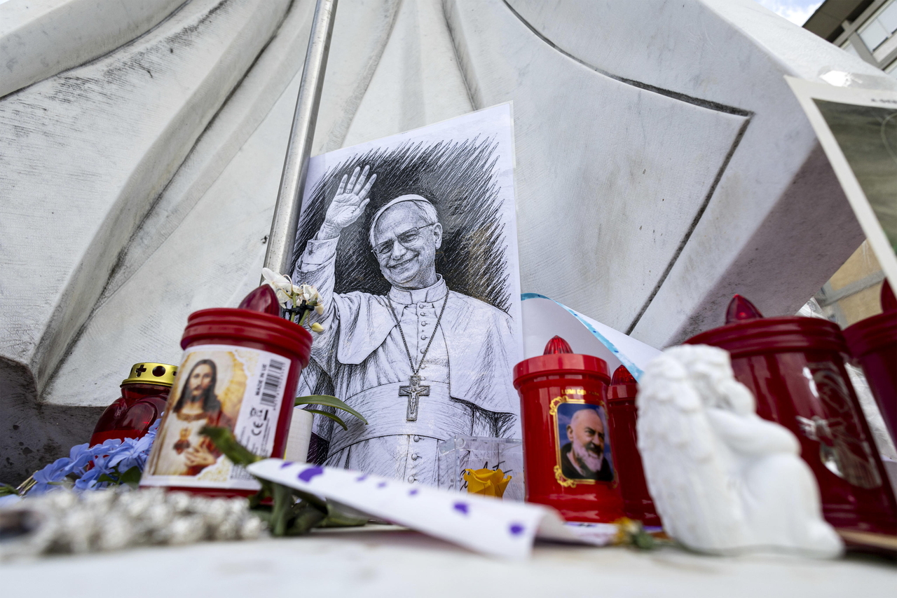 A portrait of Pope Leo XIV is placed before a statue of John Paul II outside Agostino Gemelli University Hospital in Rome, Italy, on Saturday. Pope Leo XIV is recovering at the hospital following lung surgery. [EPA]