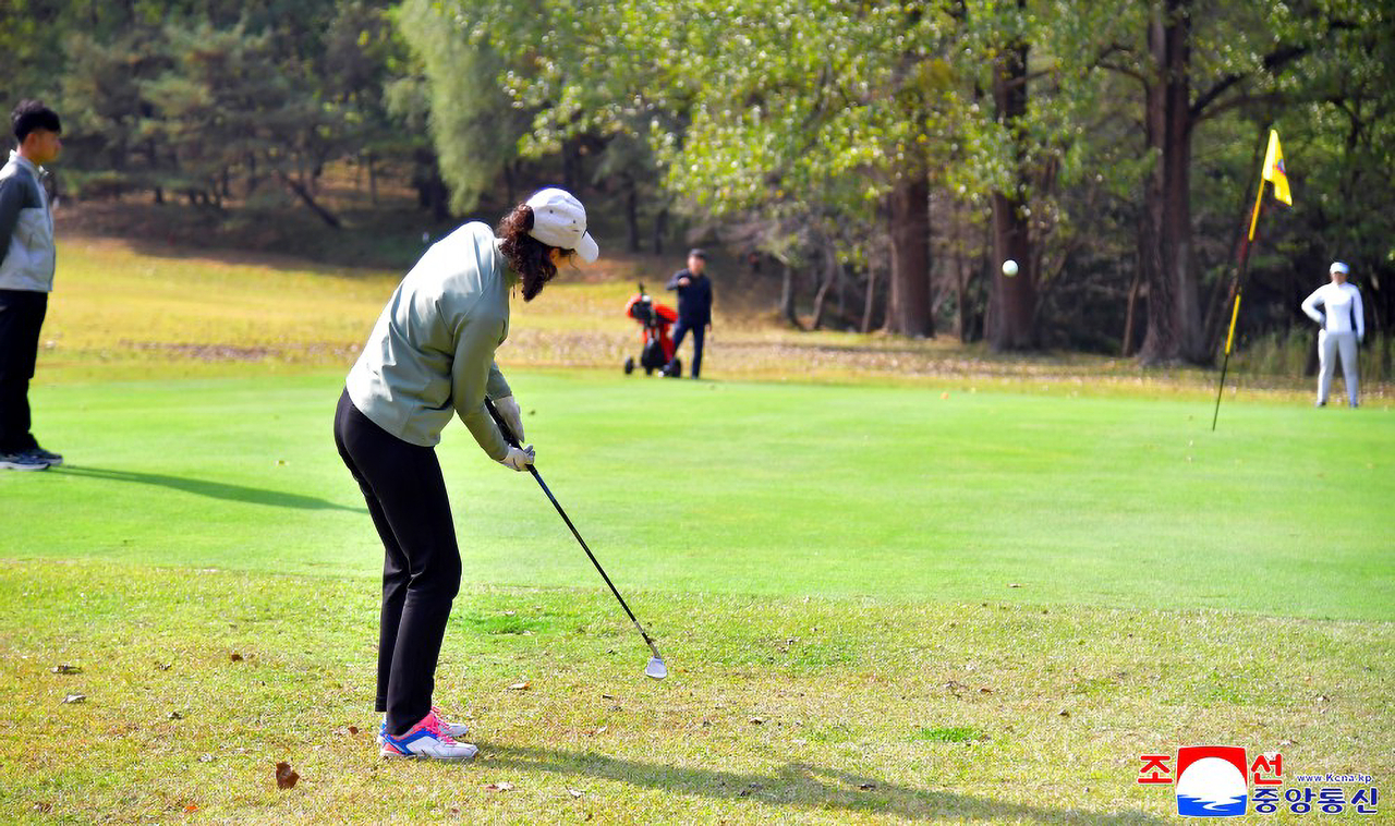 A woman hits a golf ball at the Pyongyang Golf Course in Pyongyang in this photo released Friday, as fellow players watch nearby. (KCNA via Yonhap)