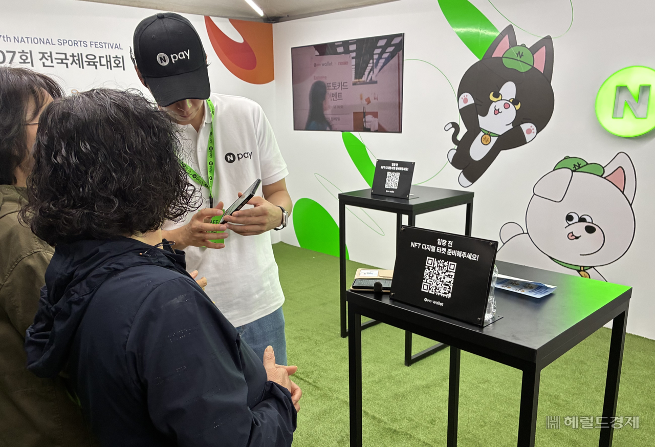 지난 16일 제주 서귀포시 제주월드컵경기장에서 열린 제107회 전국체육대회 개회식에서 네이버페이(Npay) 직원이 관람객의 대체불가능토큰(NFT) 티켓 발급을 돕고 있다. 김서현 기자
