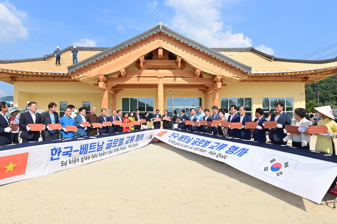South Korean and Vietnamese officials pose for a photo in front of a new multicultural center built using traditional Vietnamese archietecture styles in Bonghwa in 2025. (Bonghwa)