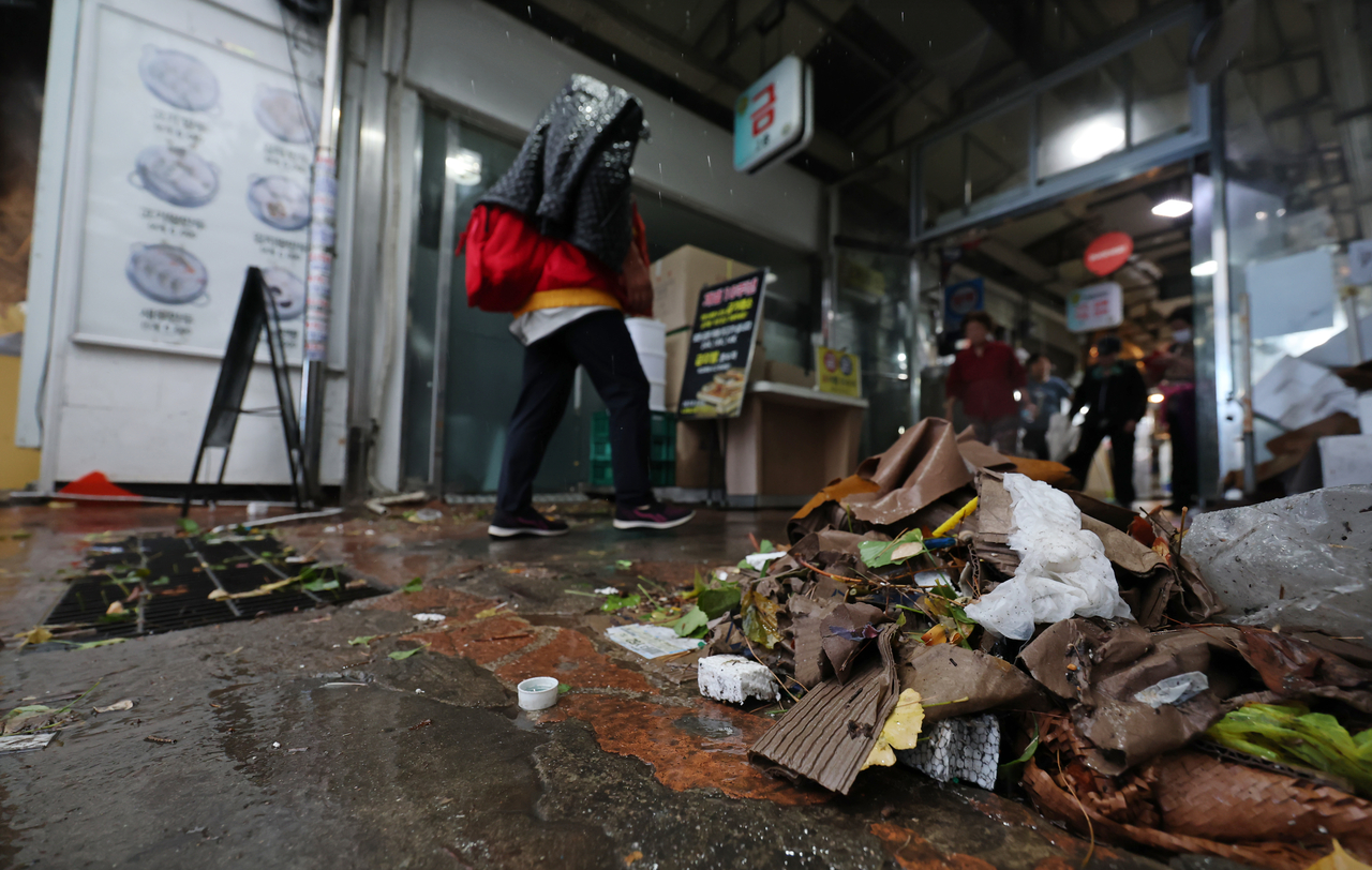 Fallen leaves and trash pile up around a storm drain at a market near Yeonsinnae in Eunpyeong-gu, Seoul, Sunday. (Yonhap)