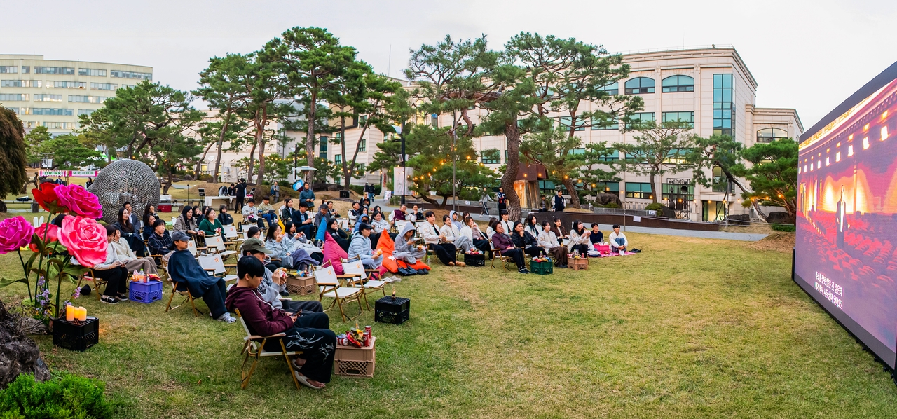 지난 15일 대구보건대 인당뮤지엄 조각공원에서 재학생들이 문화예술 프로그램 ‘달빛시네마’의 상영작 ‘그린북’을 관람하고 있다.[대구보건대 제공]