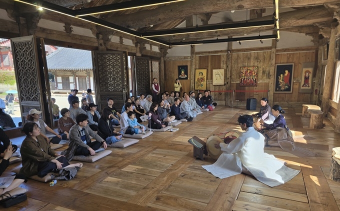 17일 화엄사 보제루 특별무대에서 열린 해금 독주회를 찾은 관람객들이 마룻바닥에 앉아 영산회상의 깊은 선율을 감상하고 있다.