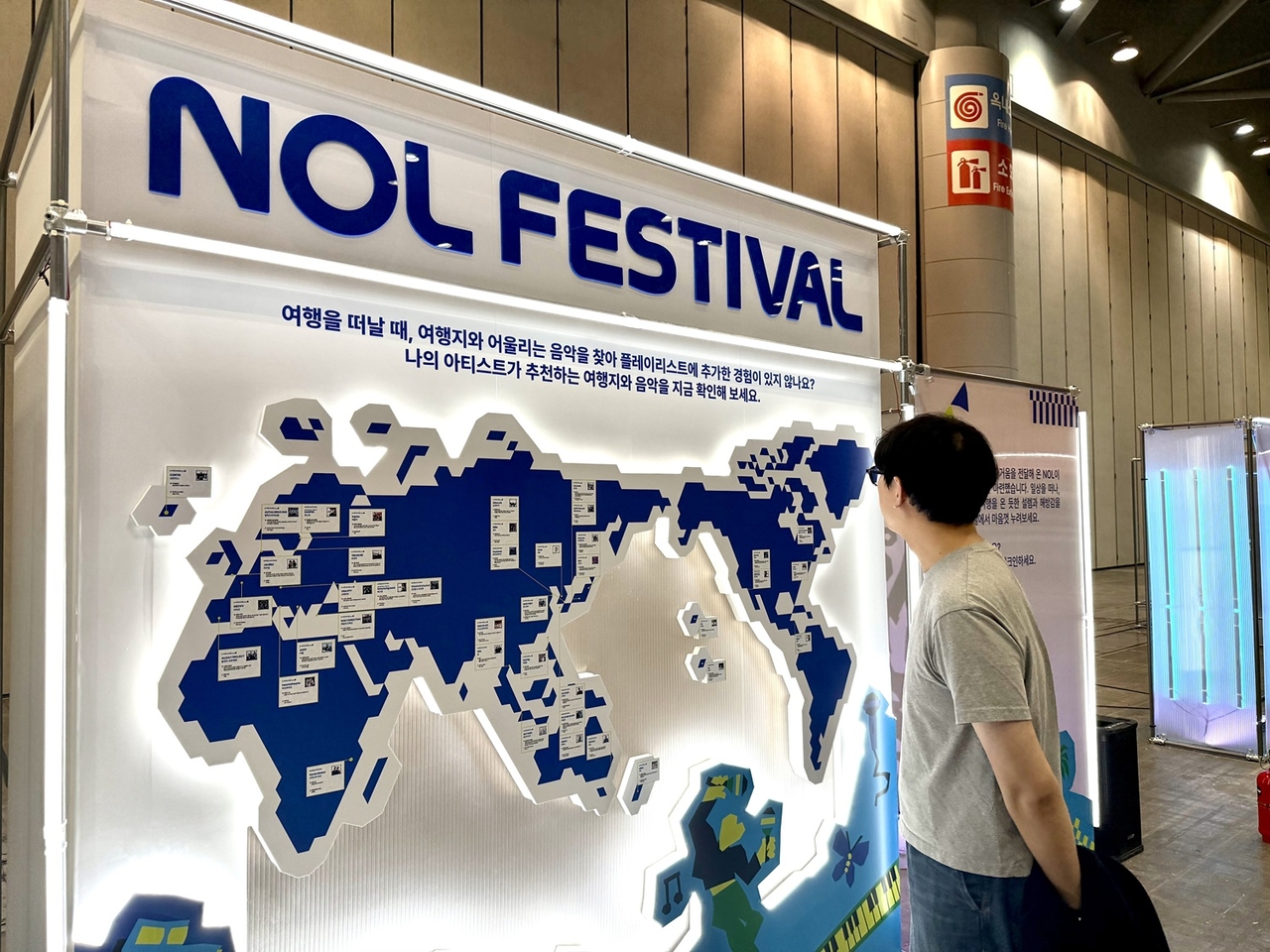 Festivalgoers browse artist-recommended travel destinations at the NOL brand zone. [NOL Universe]