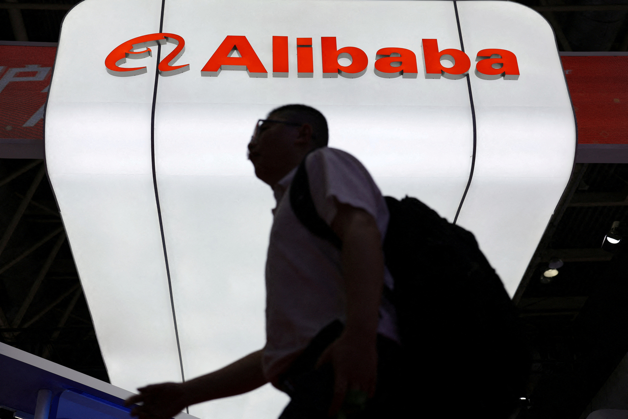 A man walks past an Alibaba booth at the China International Supply Chain Expo in Beijing. [Reuters]