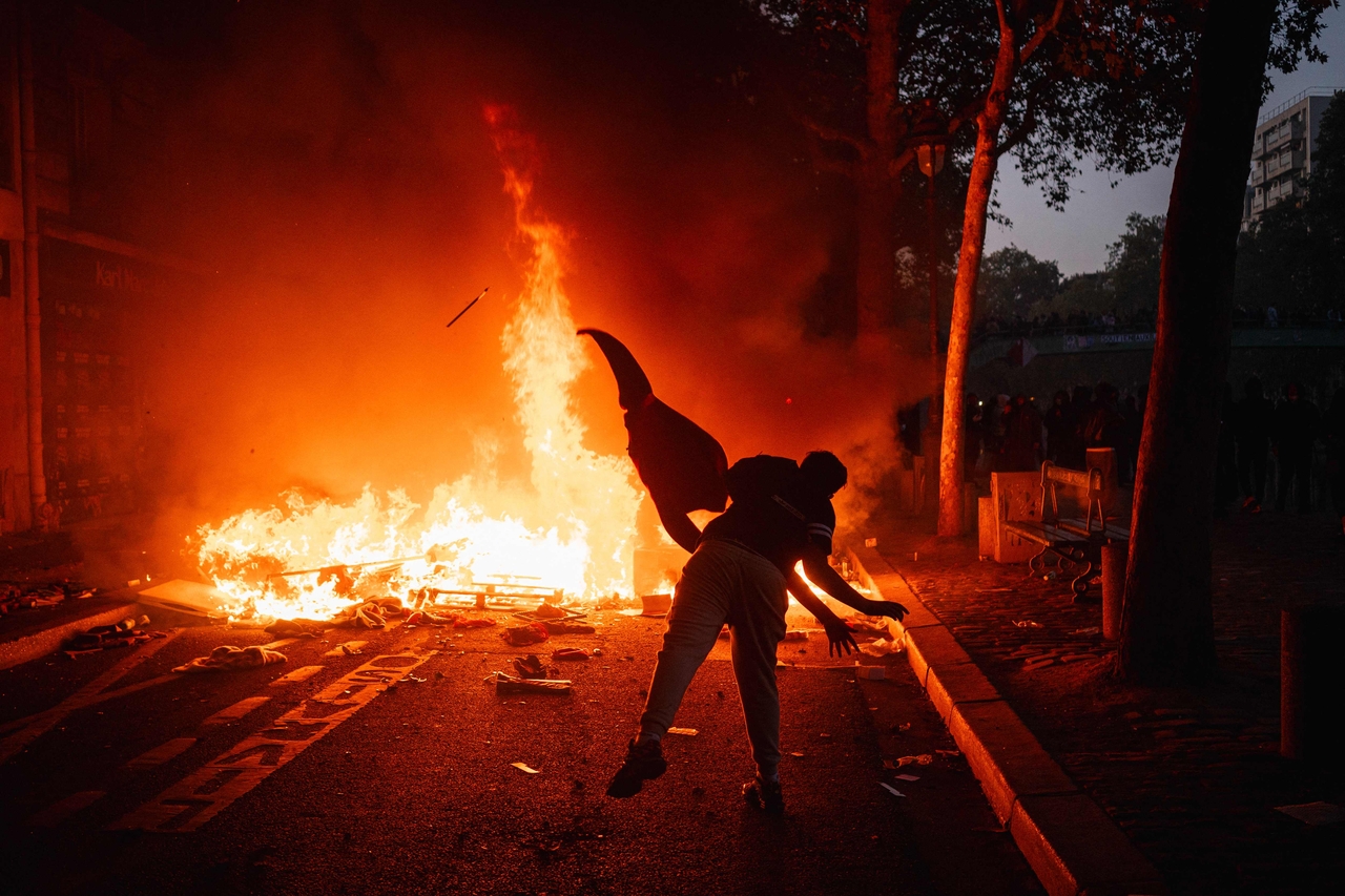 A protester feeds a fire with a material along the Canal Saint-Martin during ongoing protest in Paris on Saturday. (AFP-Yonhap)