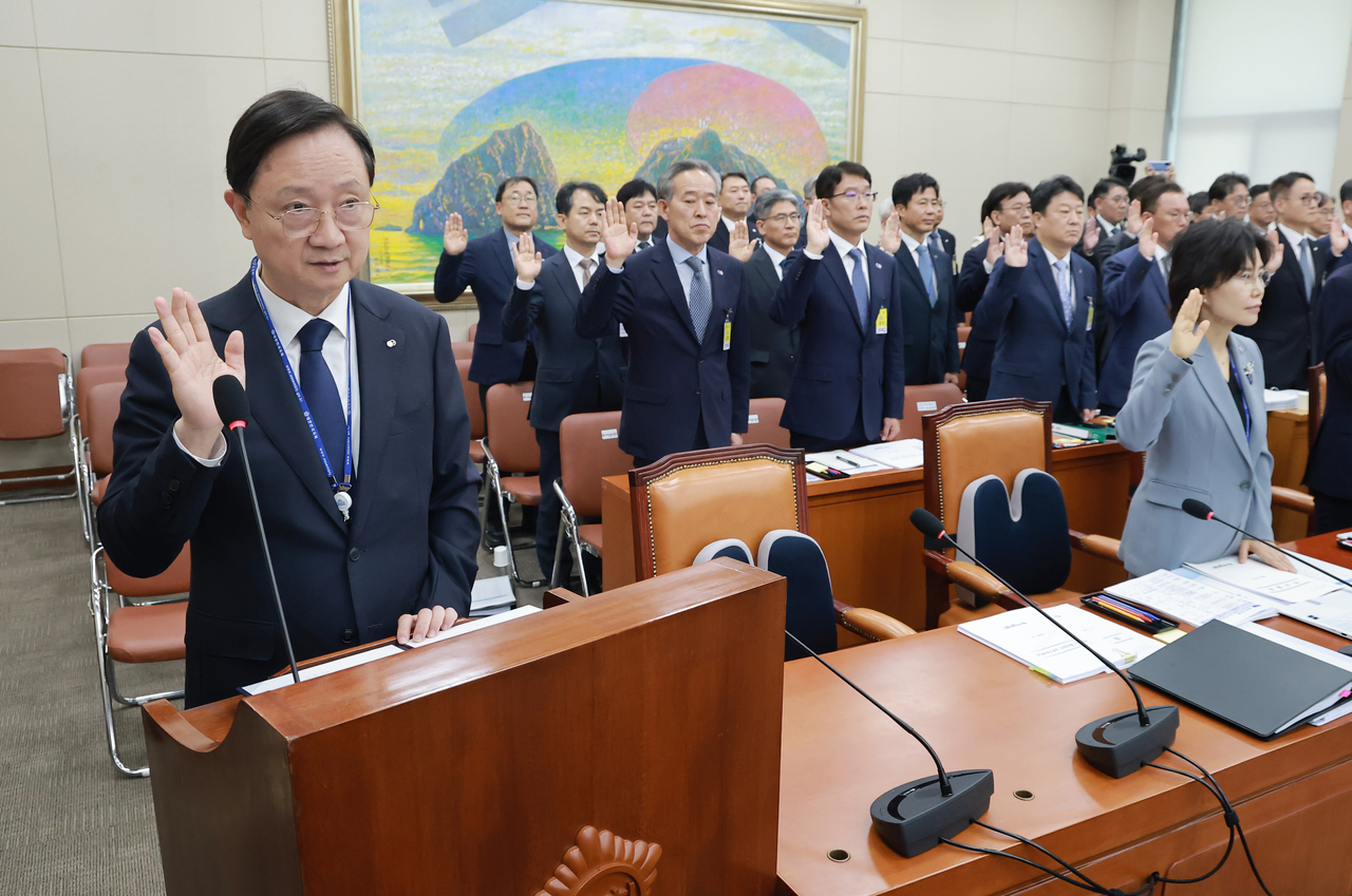 Financial Supervisory Service  Gov. Lee Chan-jin (L) takes an oath during a parliamentary audit on the FSS at the National Assembly in Seoul on Monday. (Yonhap)