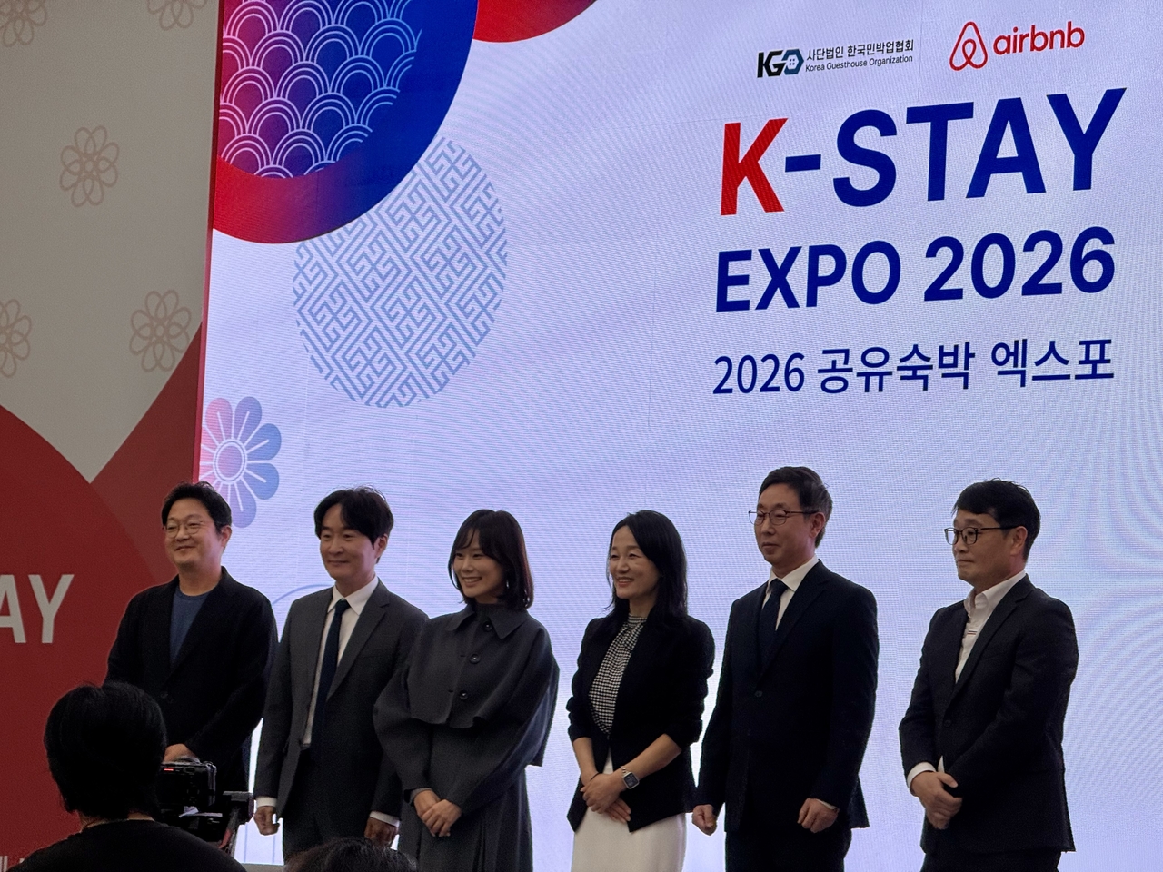 ‘K-Stay Expo 2026’ 개회식에서 주요 참석자들이 기념 촬영을 하고 있다. (왼쪽부터) 박준수 LG유플러스 IB외국인상품팀 부장, 서원석 한국관광학회장, 서가연 에어비앤비 코리아 컨트리매니저, 이재정 국회 문화체육관광위원회 위원장, 채보영 사단법인 한국민박업협회 회장, 김근수 세스코 법인컨설팅본부 사업부장 [김명상 기자]