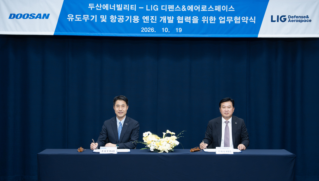 19일 경기도 성남시 분당두산타워에서 개최된 MOU 체결식에서 LIG D&A 박태식 미사일시스템사업부문장(오른쪽)과 손승우 파워서비스BG장이 서명하는 모습. [두산에너빌리티 제공]
