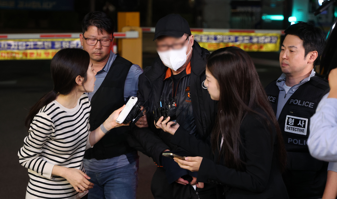 A man in his 70s suspected of setting fires at two buildings in Seoul's Gangnam district is taken to Suseo Police Station for questioning on Tuesday. (Newsis)
