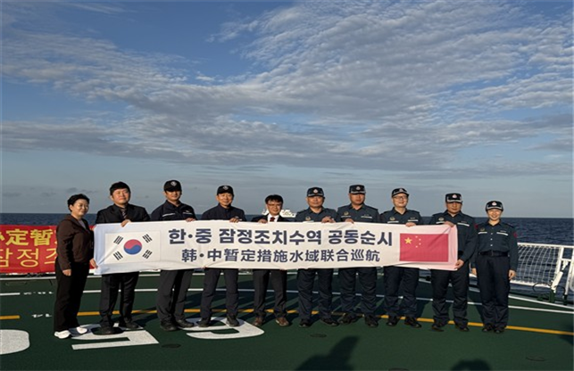 South Korean and Chinese fisheries enforcement officials pose for a photo after meeting in the South Korea-China provisional measures zone in the Yellow Sea for a joint patrol. [Ministry of Oceans and Fisheries]