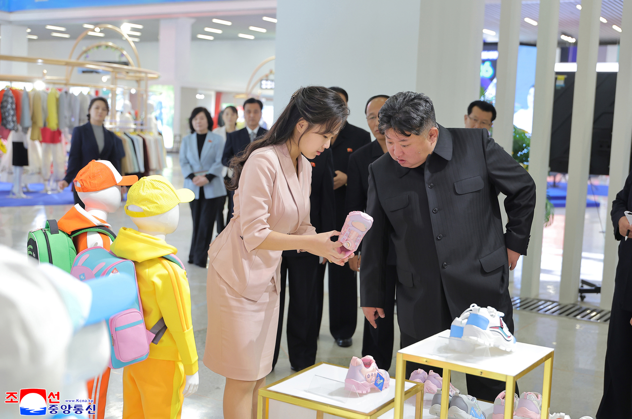 This photo, carried by North Korea's official Korean Central News Agency on Tuesday, shows the North's leader Kim Jong-un (R) and his daughter, Ju-ae, touring the 2026 National Garment and Footwear Exhibition the previous day. (Yonhap)