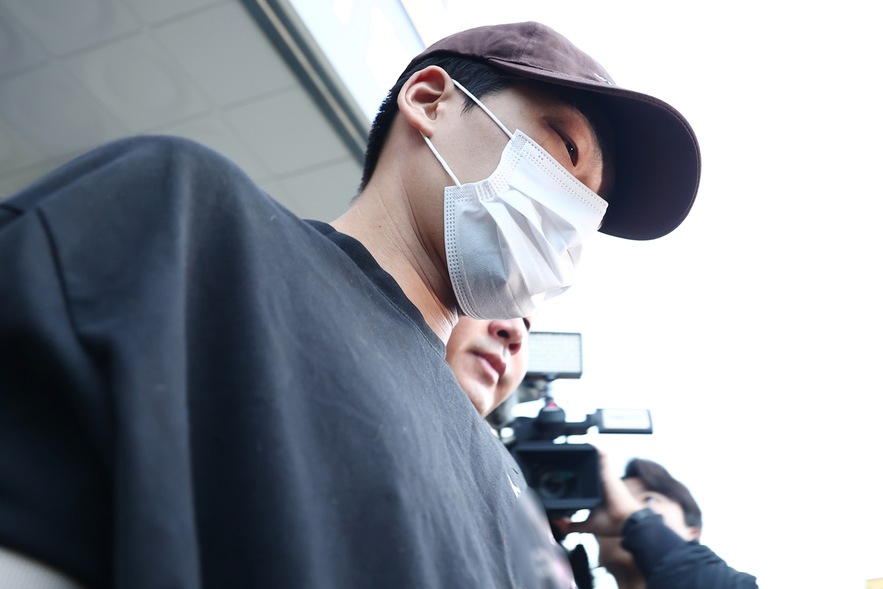 Kim Sung-woo, accused of killing his mother-in-law and abducting his wife, is escorted from Songpa Police Station in southern Seoul on Tuesday before being referred to the Public Prosecution Service. (Yonhap)
