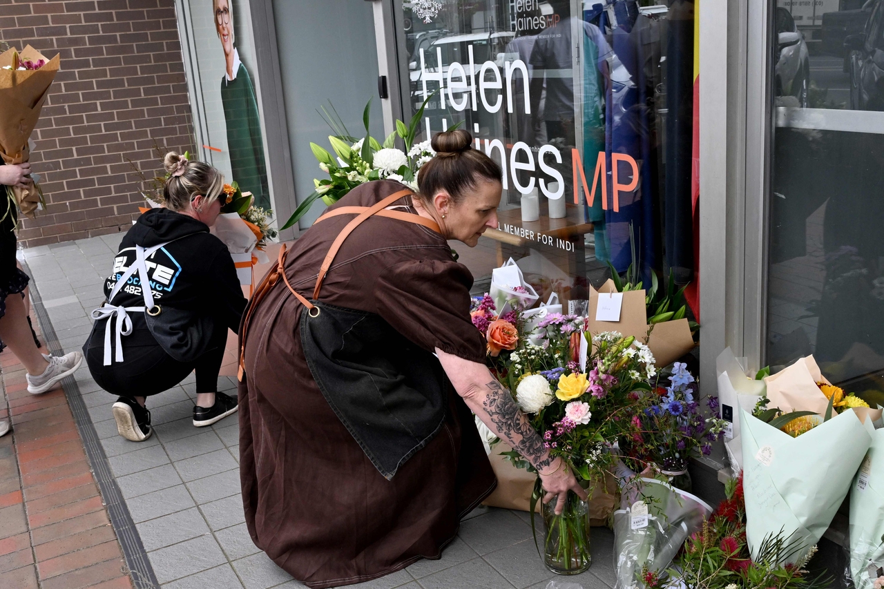 People lay flowers outside the office of Australian politician Helen Haines in the northern regional city of Wangaratta, Australia, Tuesday. (AFP-Yonhap)