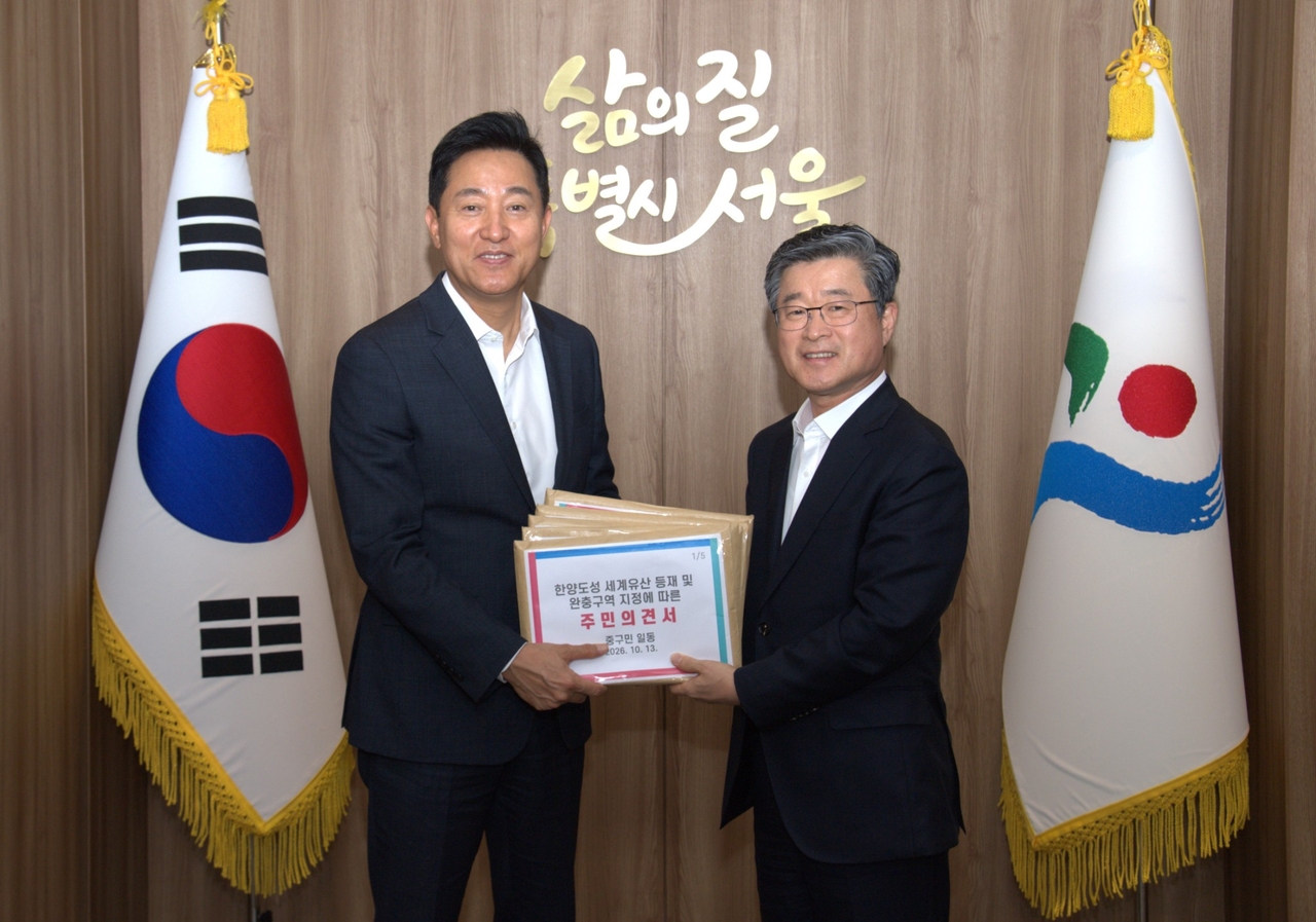 김길성 중구청장(오른쪽)이 오세훈 시장에게 전달하고 있다.