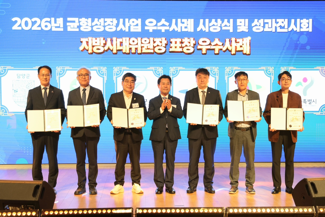 박정현 지방시대위원장이 21일 충북 옥천군 관성회관에서 열린 ‘2026년 지역균형성장사업 우수사례 시상식 및 성과전시회’에서 경북 의성군을 비롯한 12개 시군에 표창을 수여하고 기념 촬영을 하고 있다. [지방시대위원회 제공]