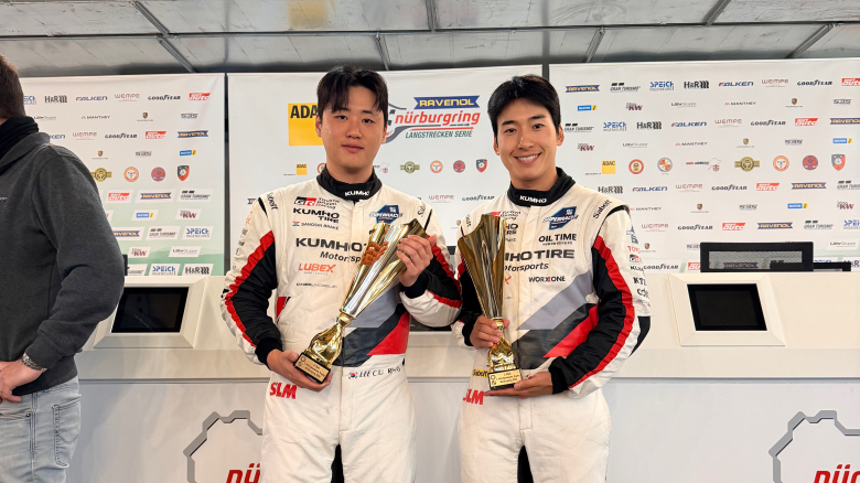 Kumho SL Motorsport team drivers Lee Chang-wook (left) and Lee Jeong-woo pose in front of the BMW M4 GT4 EVO that finished second in Round 10 of the 2026 ADAC RAVENOL Nürburgring Langstrecken-Serie (NLS). [Kumho Tire]