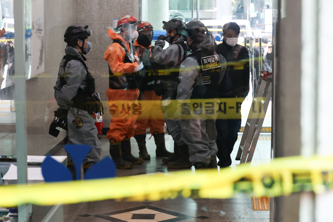 Police and fire officials enter the Hanyang Building in Yeoksam-dong, Seoul, on Wednesday to inspect the scene after fires broke out there and at a nearby building a day earlier. (Yonhap)