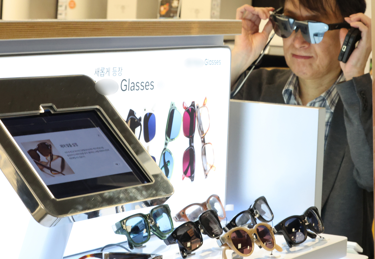 A customer tries out smart glasses at an electronics store in Seoul on Oct. 14. (Yonhap)