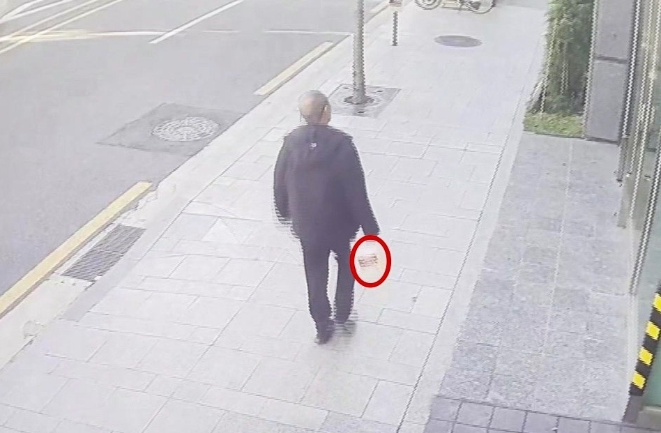 지난 20일 방화 혐의로 체포된 70대 남성 이모 씨가 화재 발생 전 인화 물질로 추정되는 물건을 들고 서울 강남구 역삼동의 한 건물을 향해 이동하는 모습. [연합]