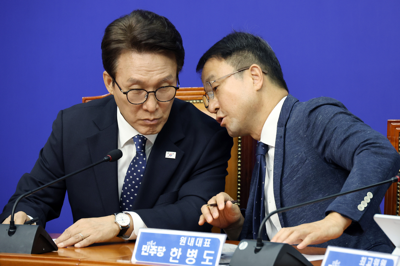 더불어민주당 김민석 대표와 한병도 원내대표가 21일 국회에서 열린 최고위원회의에서 귀엣말하고 있다. <연합뉴스>