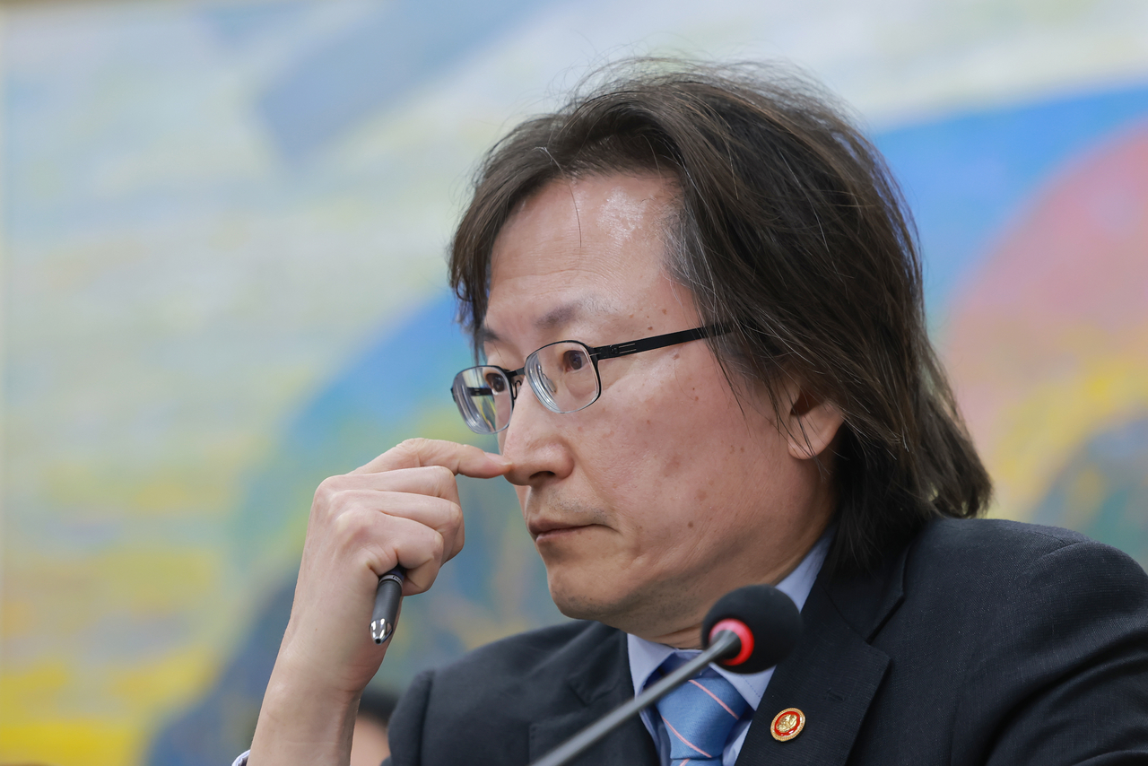 Fair Trade Commission Chairman Ju Byung-ki reviews materials prepared by a lawmaker during a comprehensive audit of the non-financial sector held by the National Assembly's Political Affairs Committee on Wednesday. [Yonhap]