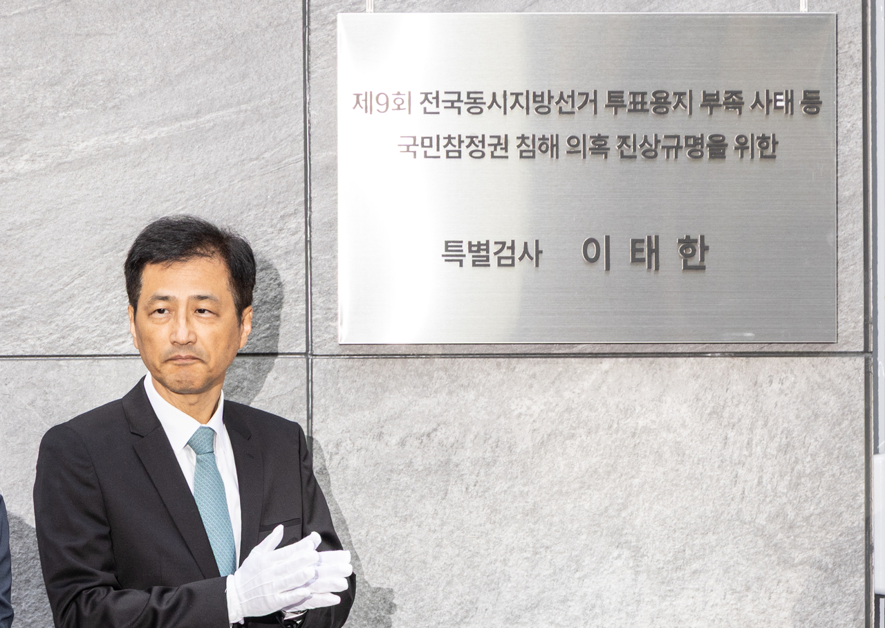 6·3 지방선거 투표용지 부족 사태 등 중앙선거관리위원회를 둘러싼 의혹을 수사하는 특별검사팀의 이태한 특별검사가 지난달 서울 서초구 특검 사무실에서 열린 현판식에서 현판을 제막하고 박수를 치고 있는 모습. 윤창빈 기자