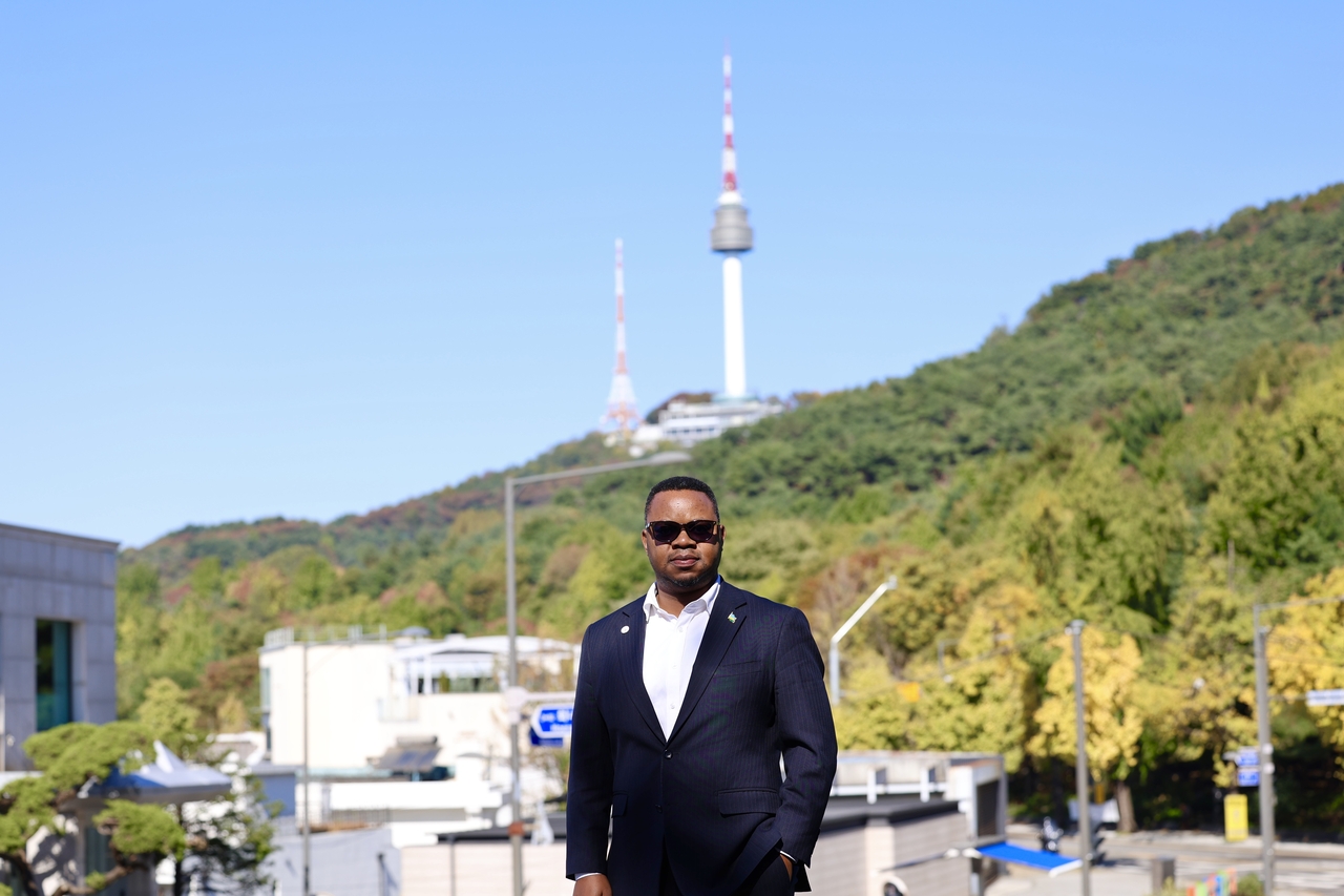 Yves Iradukunda, Rwanda’s minister of state for ICT and innovation, poses near the Grand Hyatt Seoul with Namsan  Mountain and N Seoul Tower in the background after an interview with The Korea Herald on Thursday, . (Embassy of Rwanda in Seoul)