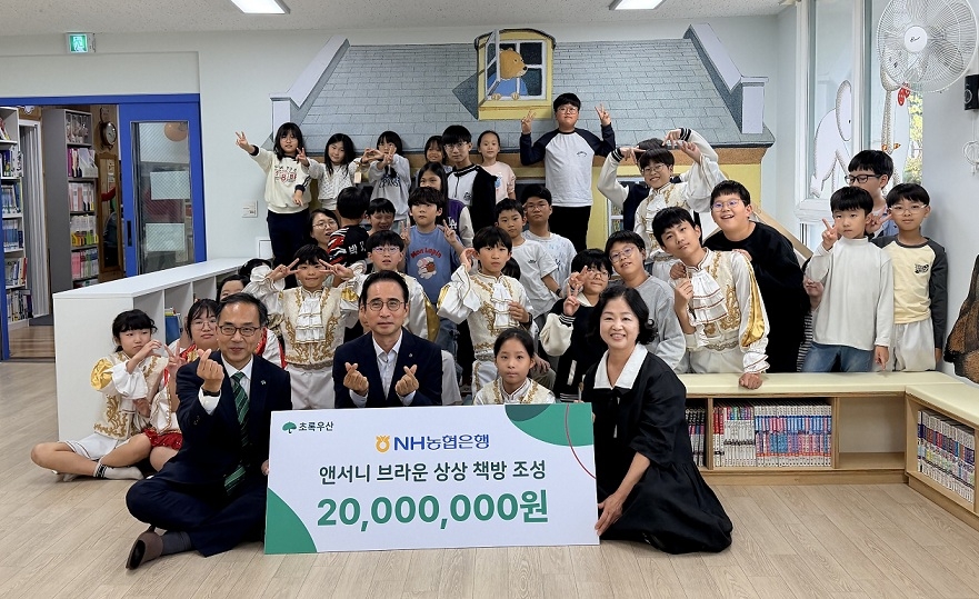 Officials from NH NongHyup Bank and other organizations pose for a commemorative photo at the completion ceremony for the "Anthony Browne Imagination Bookroom" at the Yeonhwa Community Children's Center in Asan, South Chungcheong Province, on Wednesday. [NH NongHyup provided]