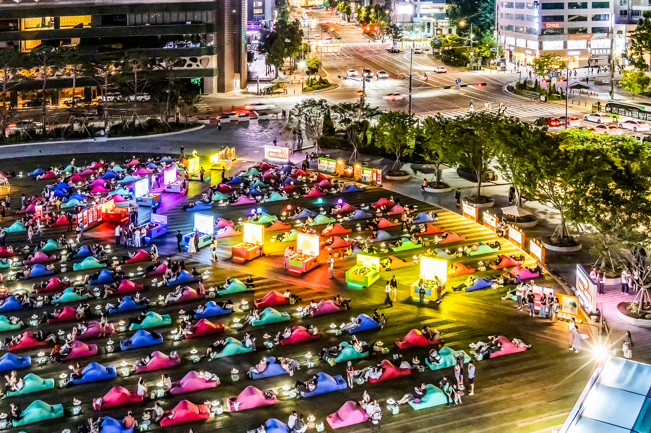 Visitors read at the Seoul Outdoor Library, which is open until 10 p.m. from Friday to Sunday through the end of October, weather permitting. (Seoul Metropolitan Government)