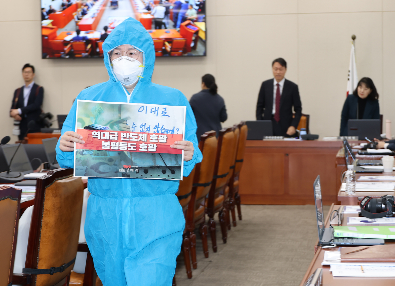 Progressive Party lawmaker Jeong Hye-gyeong enters the National Assembly chamber wearing a protective suit for the Climate, Energy, Environment and Labor Committee's national audit of the Ministry of Employment and Labor on Oct. 13. [Yonhap]