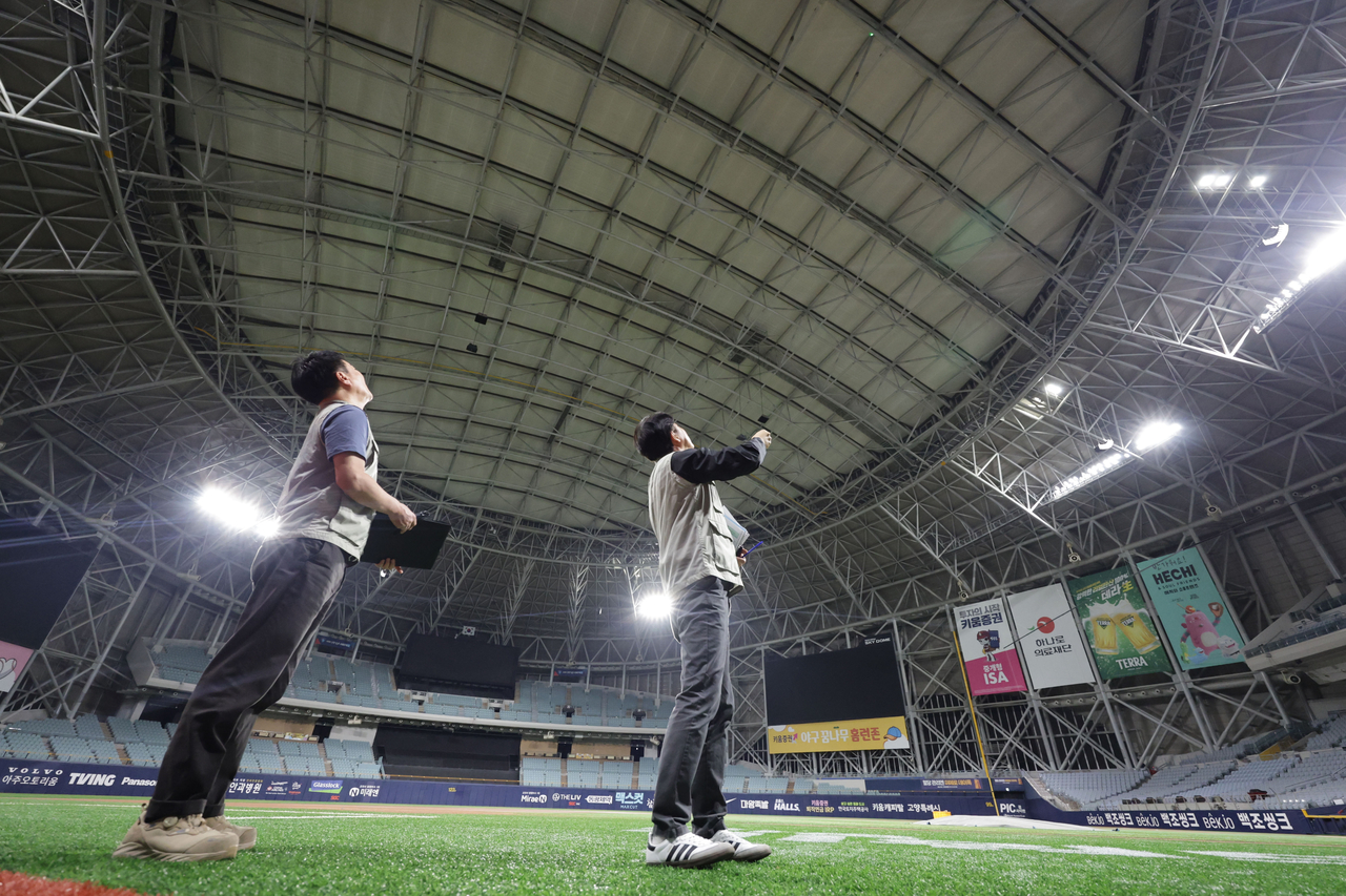 Officials from the Seoul Facilities Corporation point to a truss where load-reinforcement work has been completed at Gocheok Sky Dome in Seoul on Wednesday, the day the Board of Audit and Inspection released interim findings from its audit of safety management at major public sports facilities. The corporation said it completed reinforcement work in March — adding steel plates not only to the deformed roof trusses flagged by the audit but also to 74 adjacent trusses — after the board found that bent roof steel trusses had been inadequately reinforced on only one side. [Yonhap]
