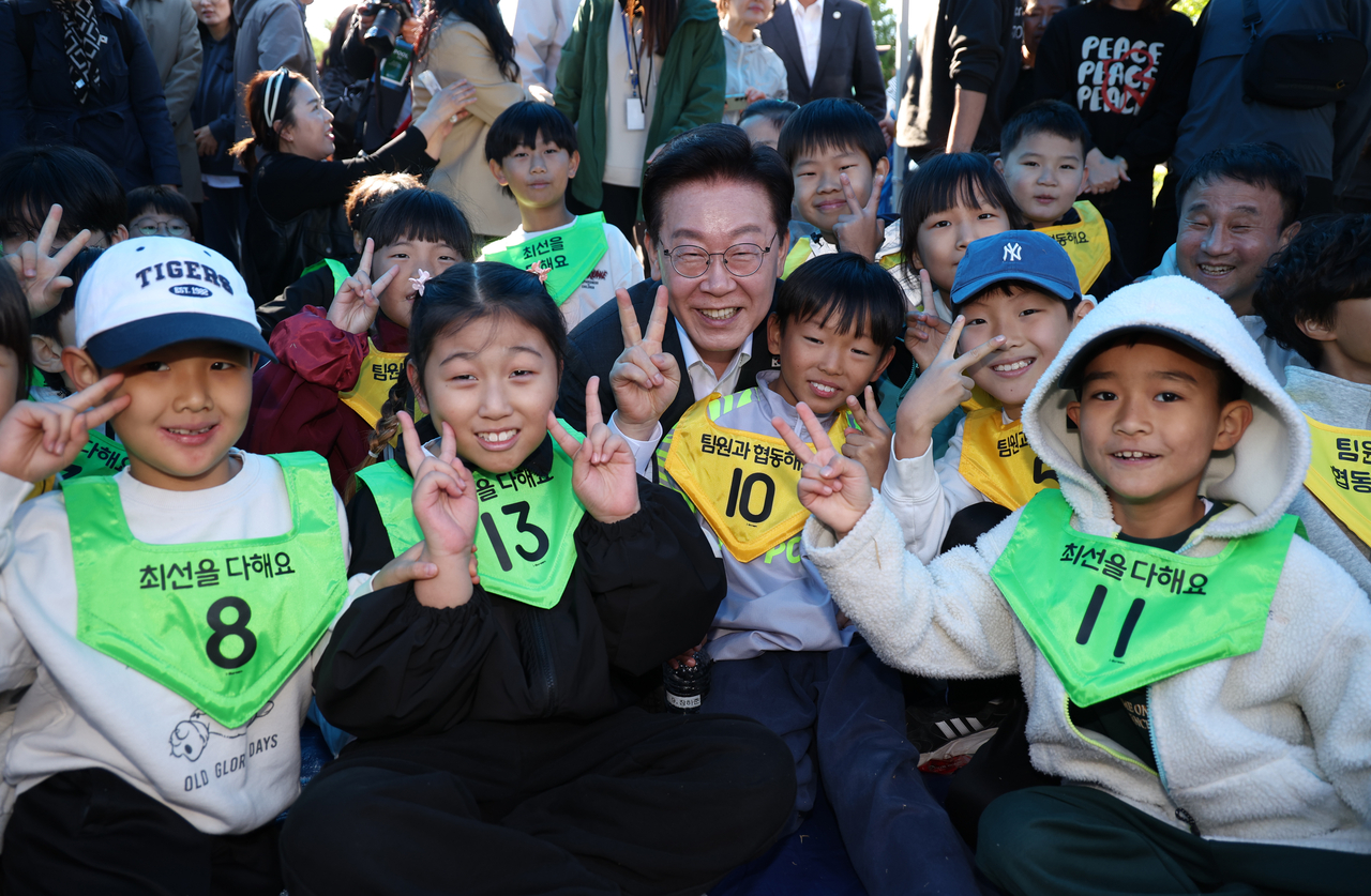 이재명 대통령이 22일 전북 익산 왕궁초등학교에서 열린 가을 체육한마당에서 학생들과 기념촬영을 하고 있다. [연합]