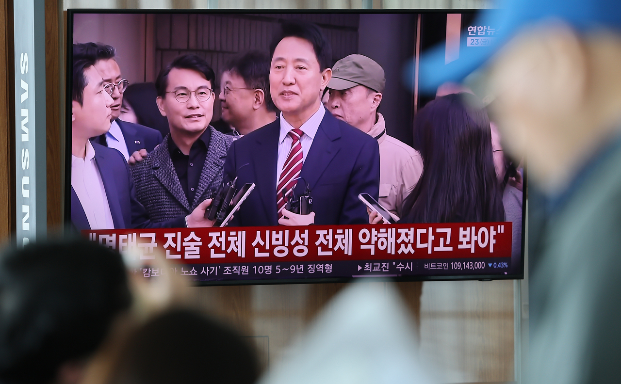 A news broadcast reporting the appellate court's not-guilty ruling in Seoul Mayor Oh Se-hoon's case involving allegations that polling costs were paid on his behalf is shown on a TV screen at Seoul Station on Friday. [Yonhap]