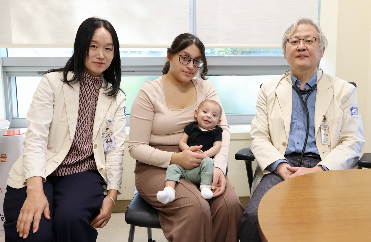 심부전 증상으로 심장 수술을 받은 미군 가족 신생아와 국제진료센터장 이지연(왼쪽) 교수, 소아청소년 심장병 클리닉을 이끌고 있는 이재영(오른쪽) 교수.[서울성모병원 제공]