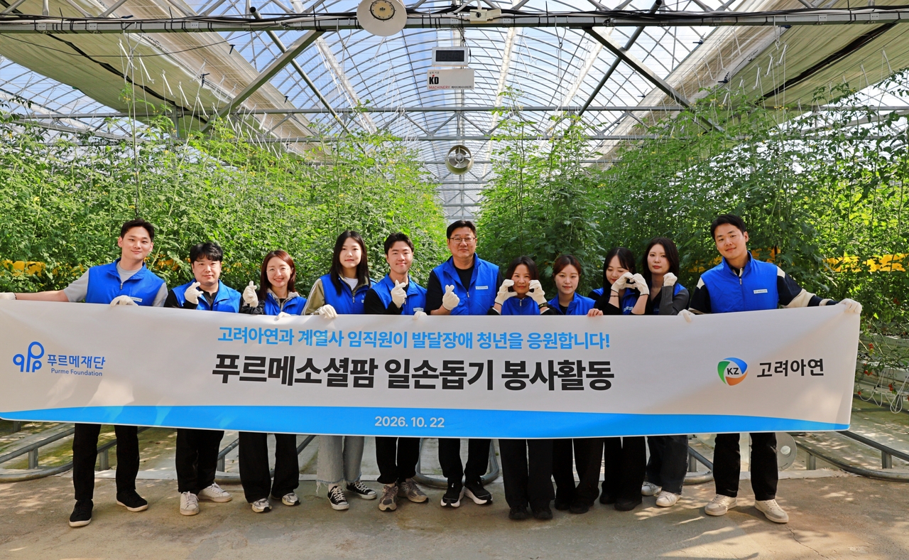Employees of Korea Zinc and its affiliates Axis IT and KZ Precision pose for a photo before volunteering at Purme Social Farm in Yeoju, Gyeonggi Province, on Thursday, where they helped young adults with developmental disabilities grow and harvest cherry tomatoes. [Korea Zinc]